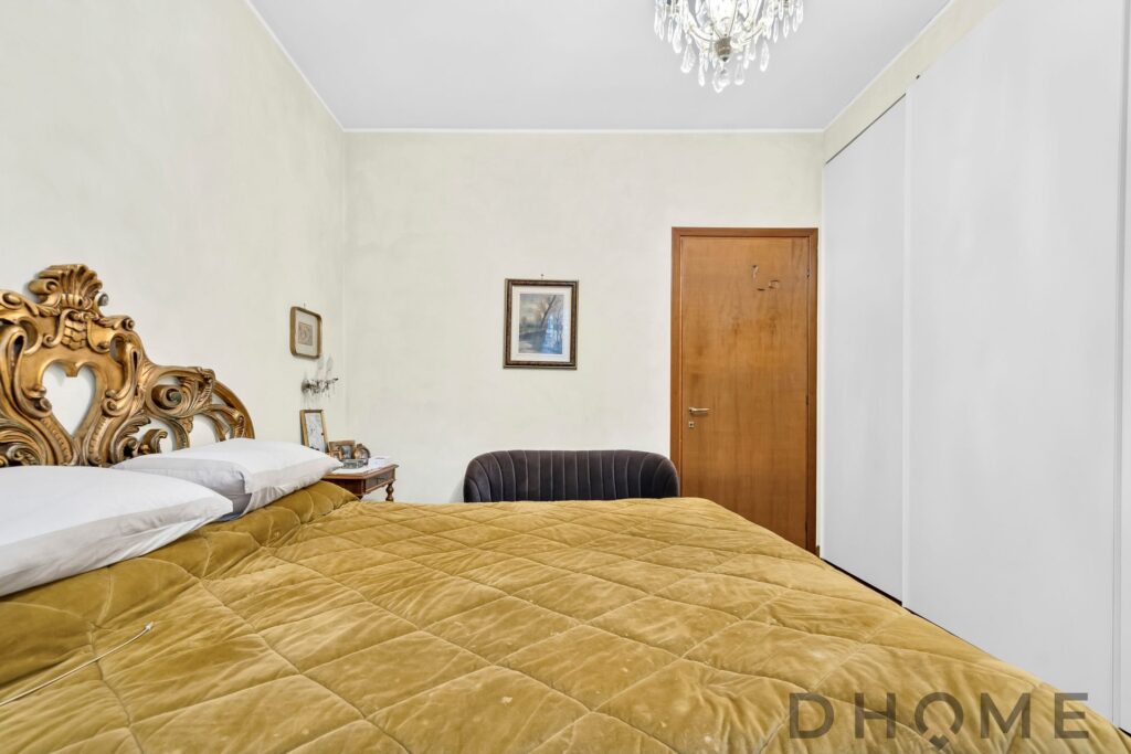 Letto matrimoniale con testiera intagliata in legno, camera da letto classica elegante.