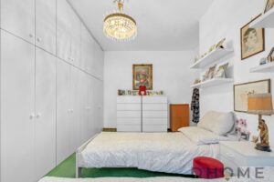 Armadio a muro bianco con ante laccate, camera da letto luminosa e arredamento elegante.