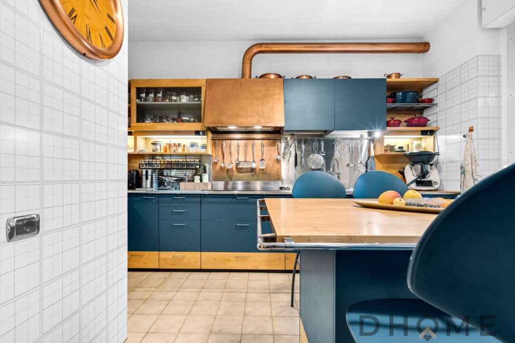 Finiture moderne cucina con credenze blu e piani in legno, dettagli e accessori di design.