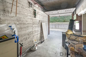 Finestra in garage con pareti in cemento grezzo, spazio di lavoro e stoccaggio.