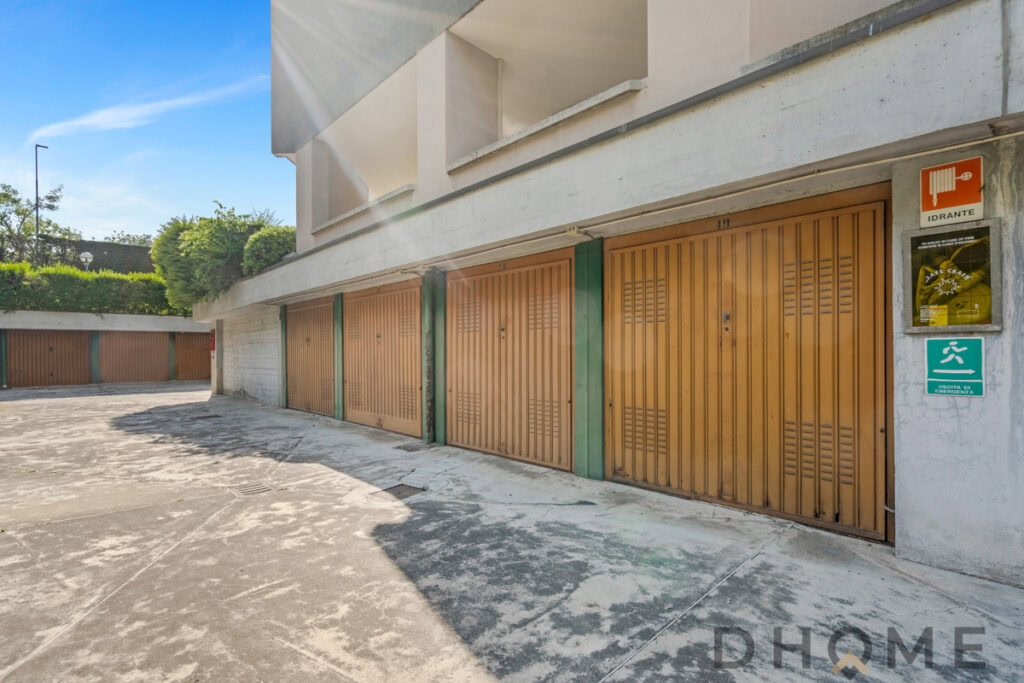 Posto auto garage in edificio residenziale con apertura automatica, area esterna sicura e adeguata sicurezza antincendio.