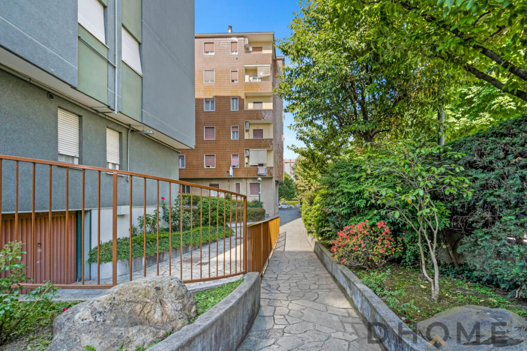 Balcone in appartamento con vista su giardino condominiale e area verde urbana.