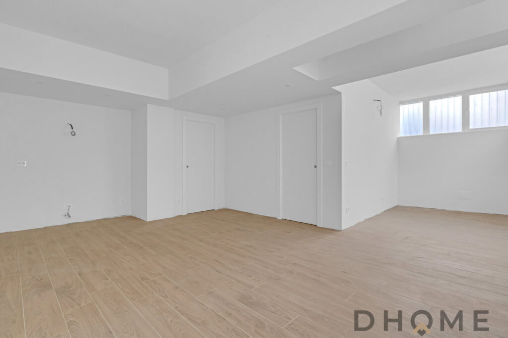 Interni moderni di un appartamento in fase di ristrutturazione, pavimento in parquet e pareti bianche.