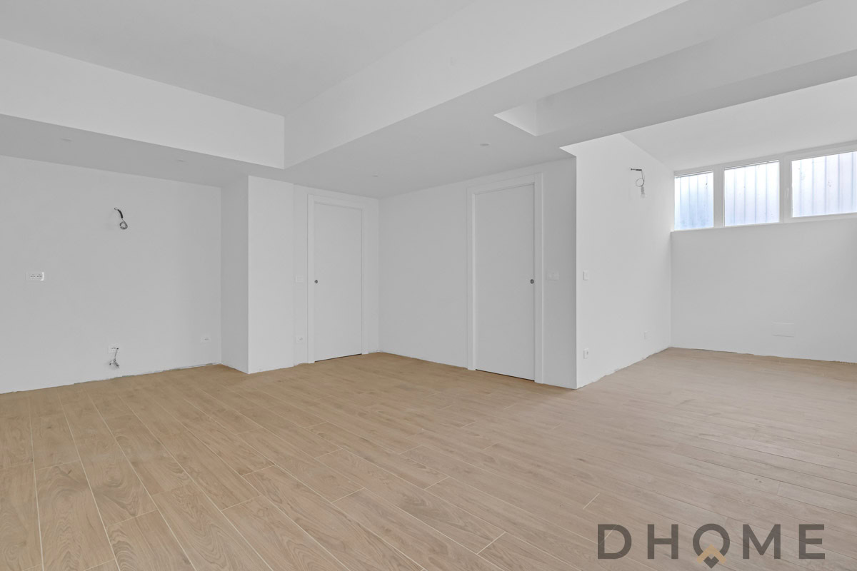 Interno di appartamento nuovo con pavimenti in legno e pareti bianche.