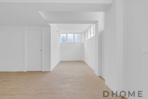 Interni moderni con pareti bianche e pavimento in legno chiaro.