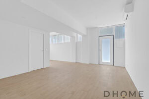 Spazio interno moderno con pareti bianche, pavimento in parquet naturale e illuminazione naturale.