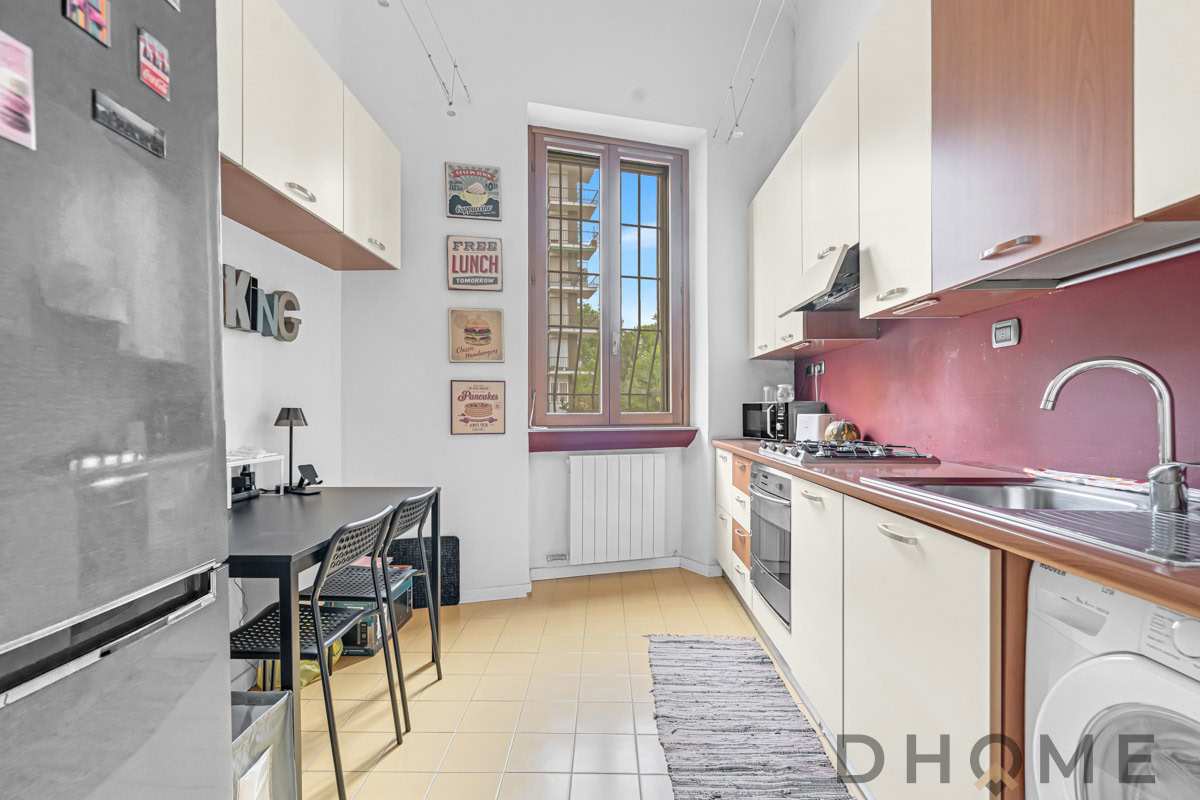 Finestra grande in cucina con arredi moderni e elettrodomestici funzionali.