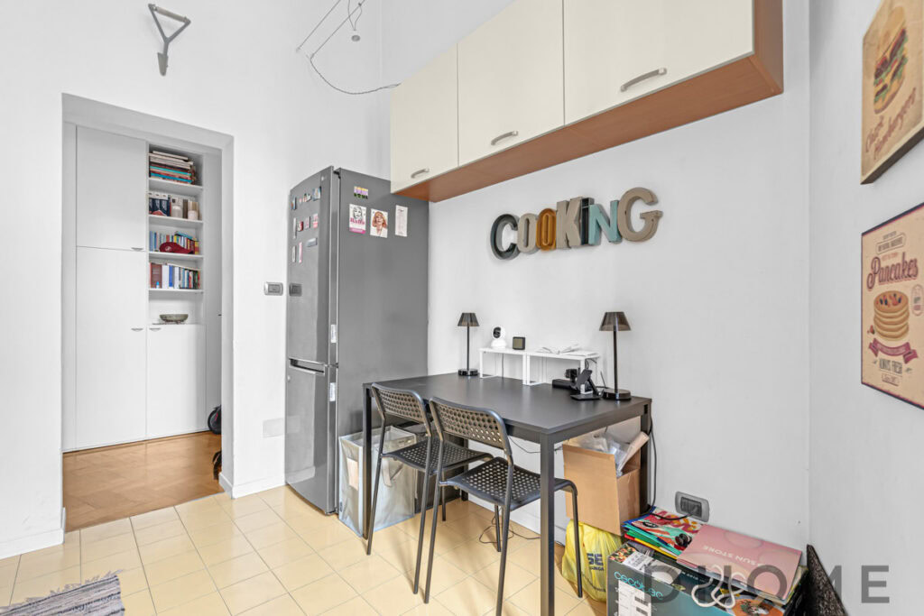 Decorazioni cucina moderna con lettere 3D e mobiletto bianco e grigio, ambiente funzionale e accogliente.