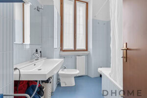 Lavabo con specchio e finestra in bagno ristrutturato.