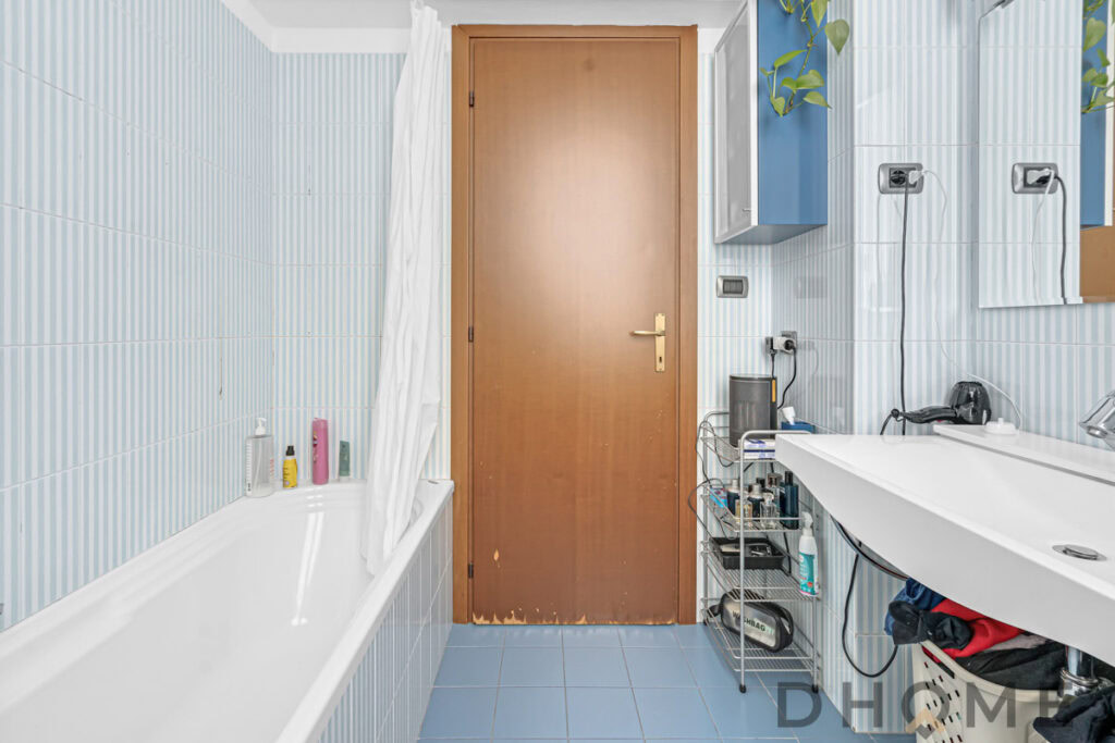 Bagno con vasca e mobili moderni, dettaglio di arredo e accessori bagno, pavimento piastrellato, stile funzionale e pratico.