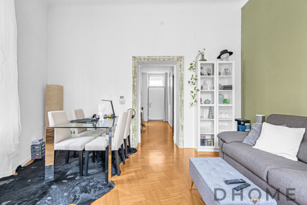 Interno soggiorno con mobile bianco e divano grigio, affaccio su soggiorno moderno, arredamento accogliente design elegante.