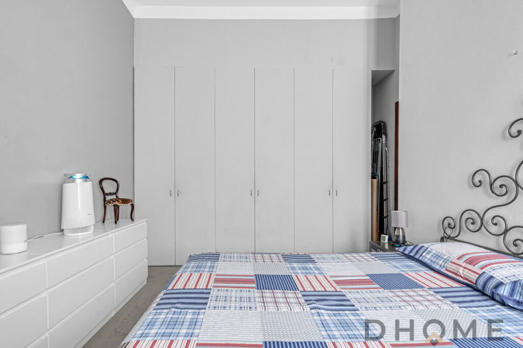 Armadio a muro con ante bianche per spazio esterno in camera da letto.