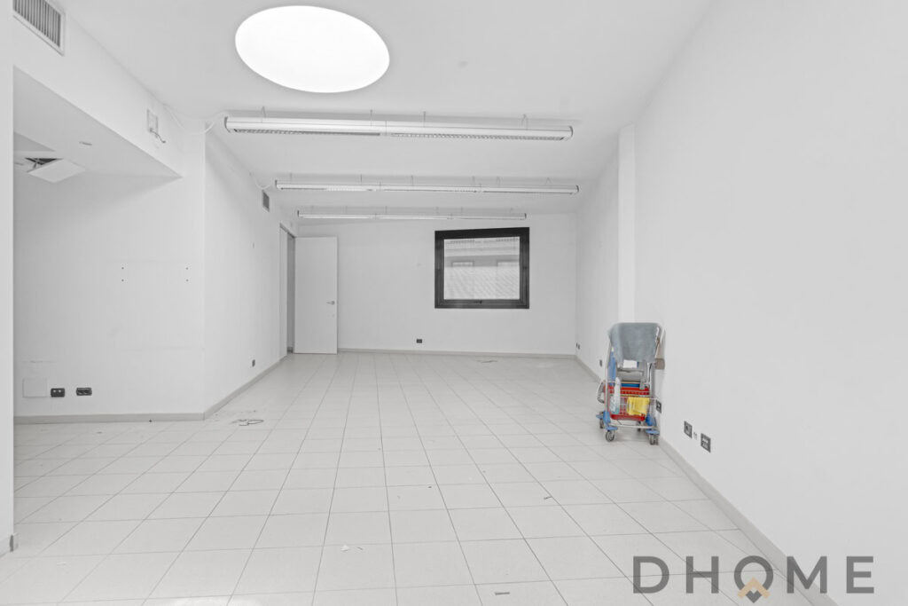 Spazio interno vuoto dotato di illuminazione a soffitto e finestra panoramica, ideale per ristrutturazioni domestiche.