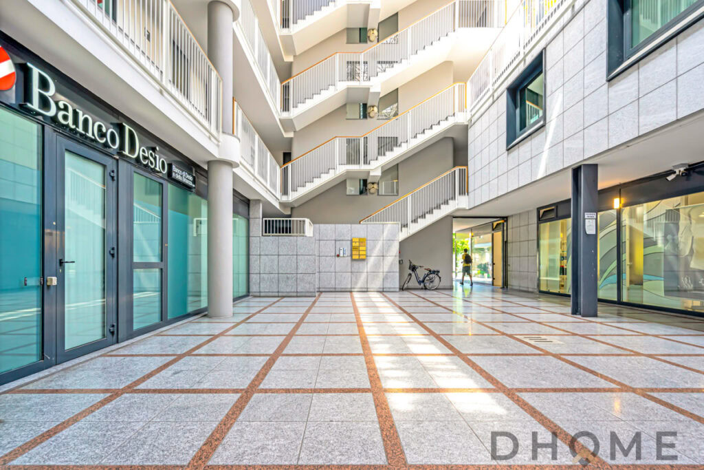 Ampio spazio commerciale e uffici moderni in edificio con ingresso elegante e aree di ufficio luminose.