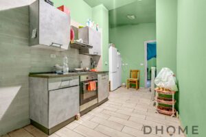 Cucina moderna con pareti verdi e mobili in pietra, spazio funzionale e accogliente.