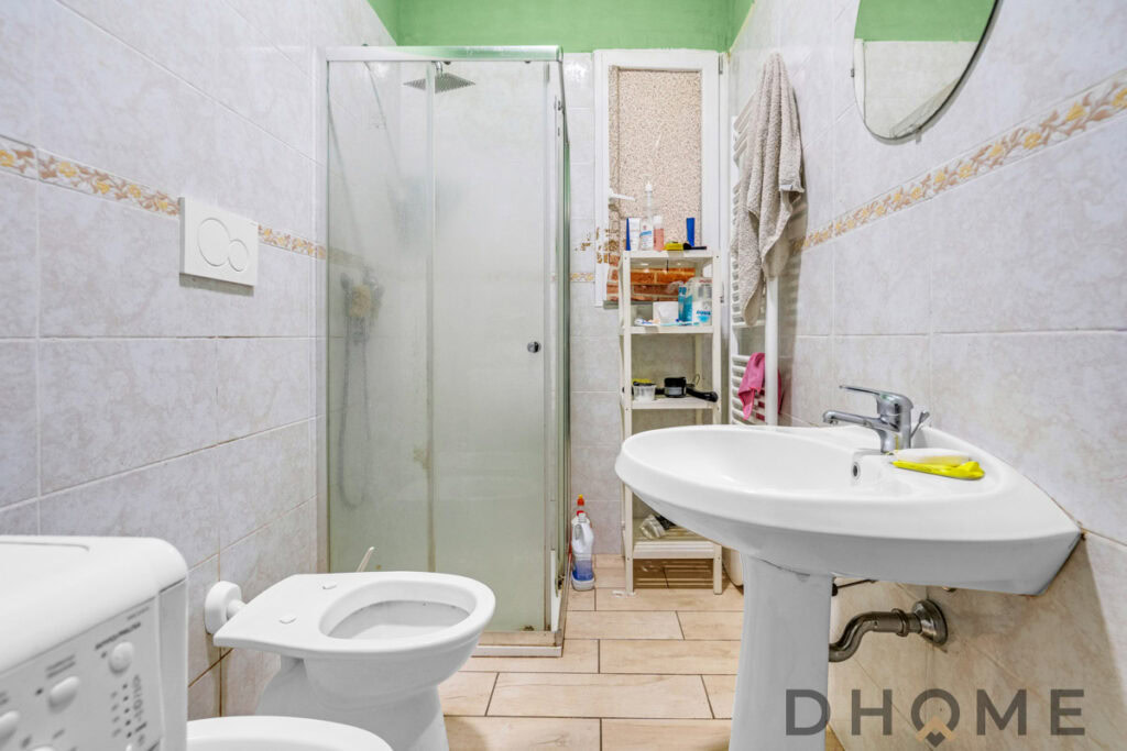 Loft bagno con doccia, lavabo e spazio di stoccaggio, arredamento funzionale e pratico. Eleganza semplice e funzionale per la casa.