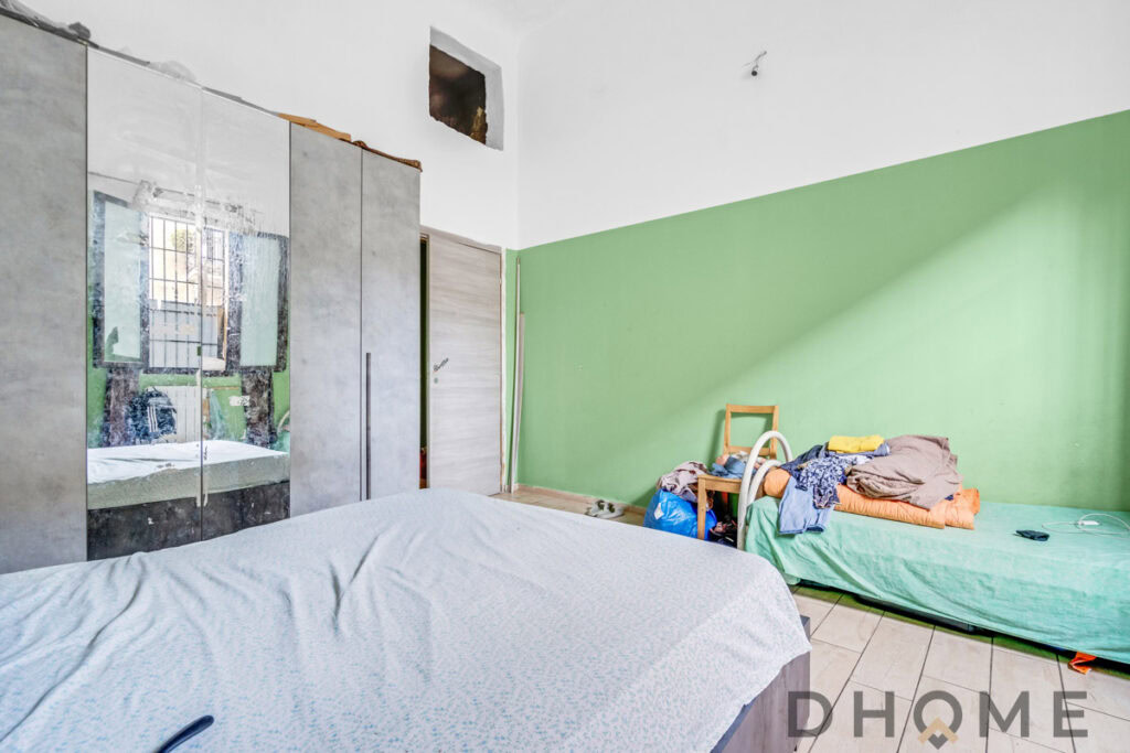 Armadio moderno con specchi e parete verde in camera da letto.