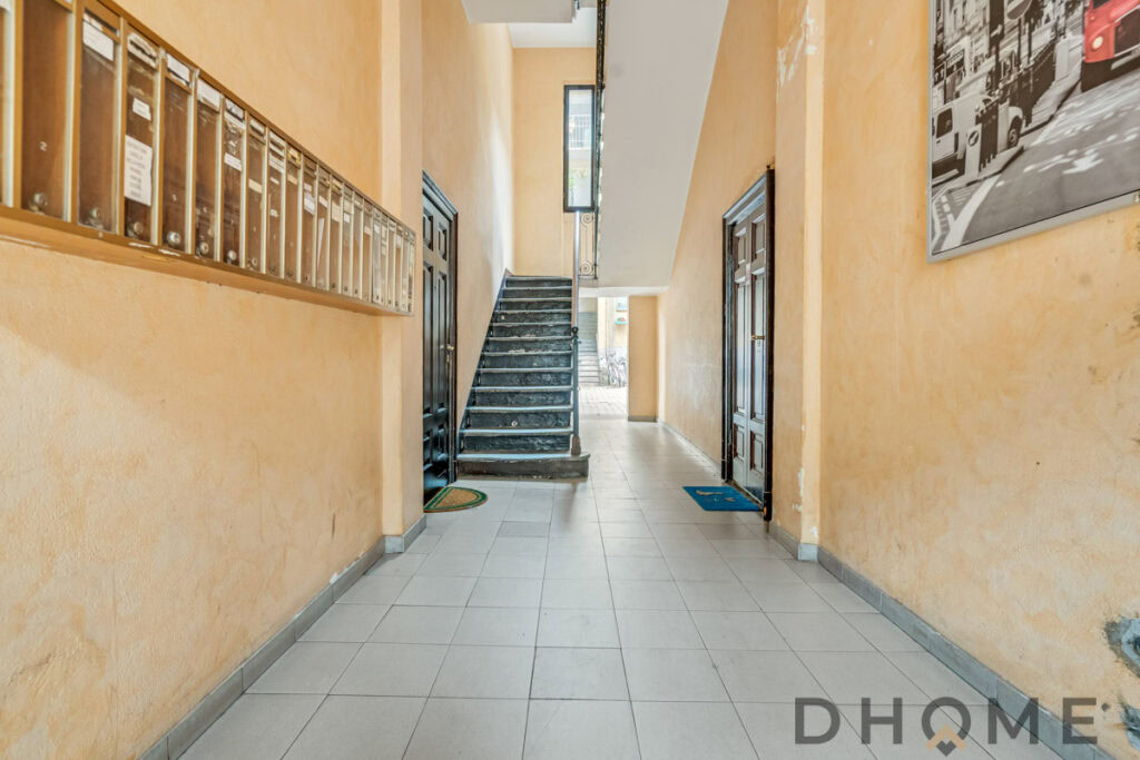 Ingresso condominiale con scale e cassette postali, ambiente luminoso e accogliente, design urbano, immobile di proprietà DHOME.