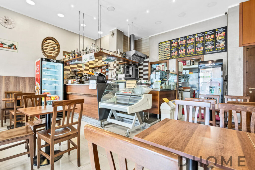 Vendita di prodotti alimentari e gastronomia in negozio di alimentari con arredamento in stile rustico.