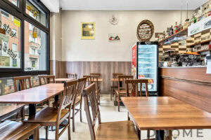 Accogliente interni di un ristorante con tavoli in legno e negozio di alimentari.