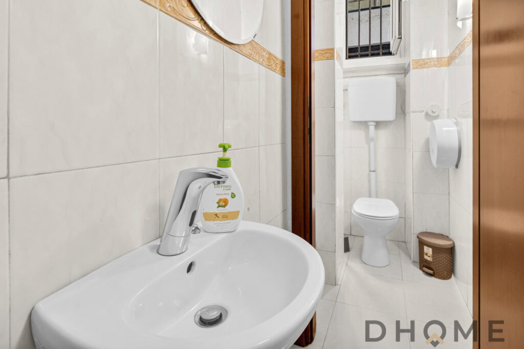 Lavandino e bagno in piccolo appartamento con sanitari moderni e dettagli di arredo funzionali.