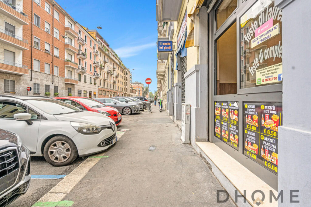 Parcheggio auto in zona urbana con negozio di alimentari DHOME.