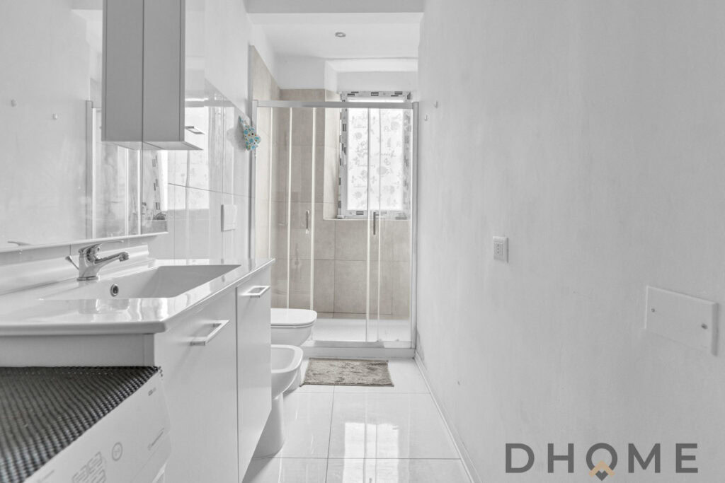 Lavanderia moderna con piastrelle chiare e spazi intelligenti, ideale per case di design.