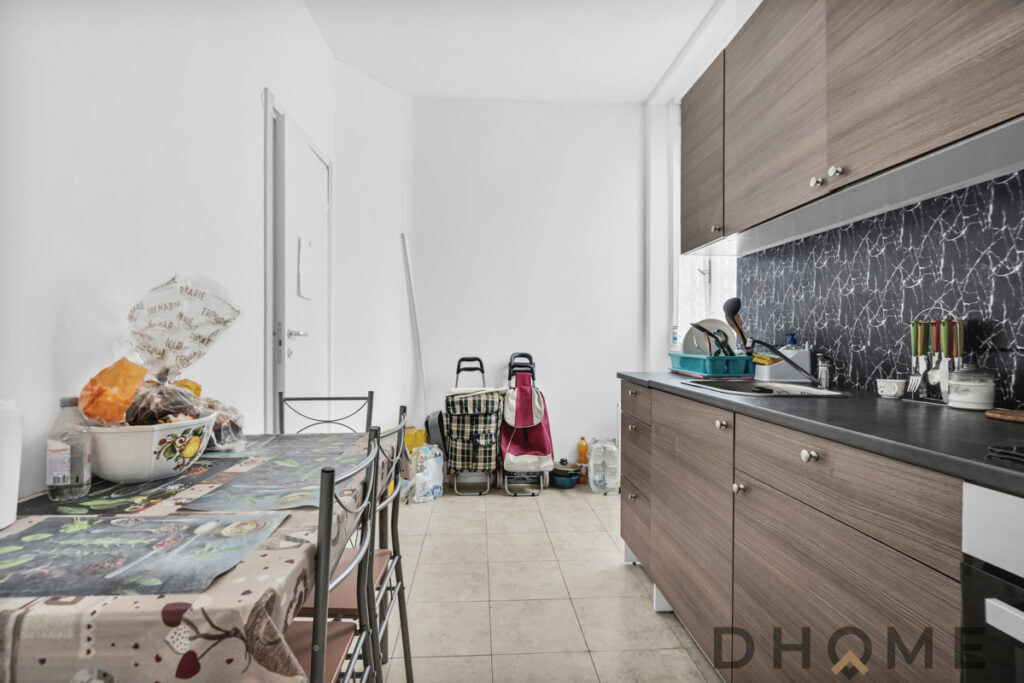 Bagno arredato con cucina moderna, dettagli in marmo nero e mobili in legno chiaro. Spazio abitabile e funzionale.