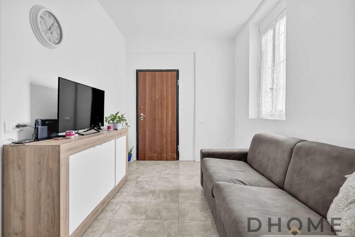 Soggiorno moderno con parete TV e divano plush in stile minimalista.