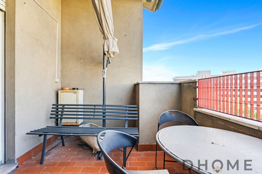Balcone con mobili da esterno e vista sulla città, ideale per relax e convivialità all'aperto.