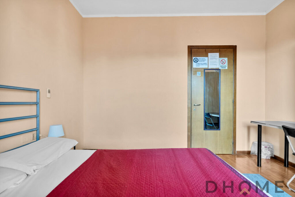 Letto matrimoniale con lenzuola bianche, stanza semplice e funzionale, hotel DHOME.