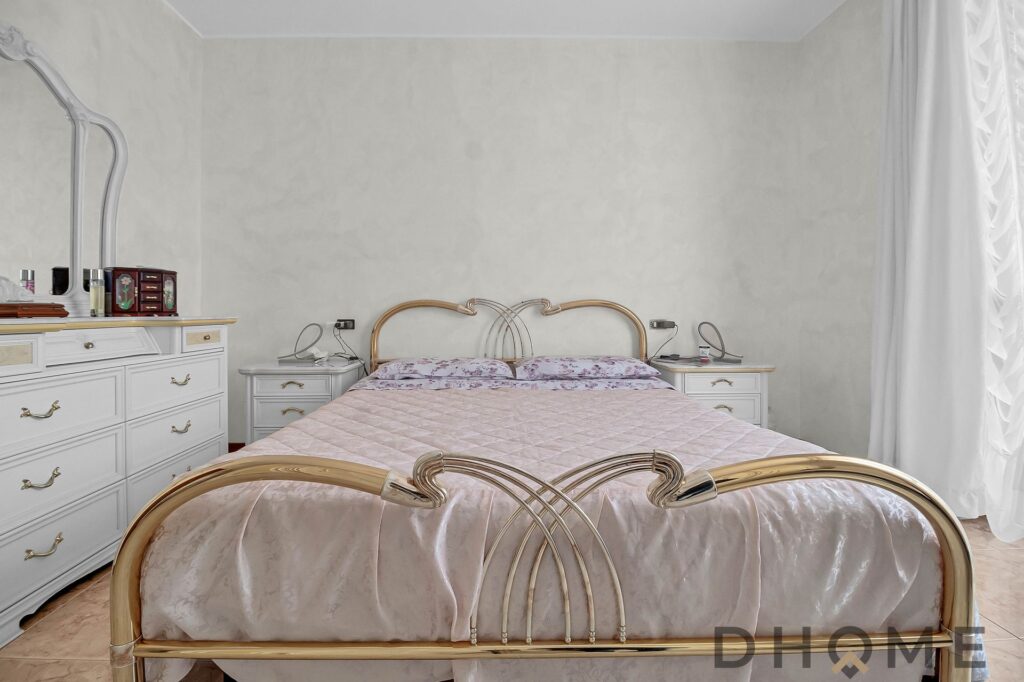 Letto matrimoniale con piumino in camera da letto, stile classico, arredi eleganti, atmosfera accogliente, decorazioni di lusso, mobili bianchi, luce naturale.