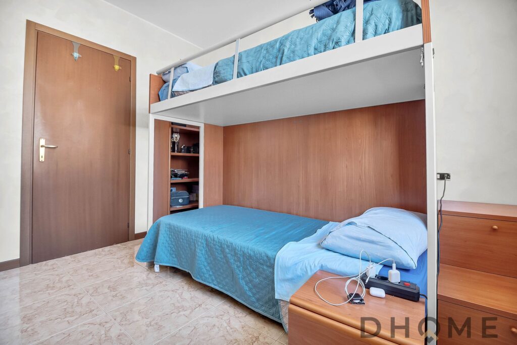 Lenzuola blu sopra letto a soppalco in camera da letto.