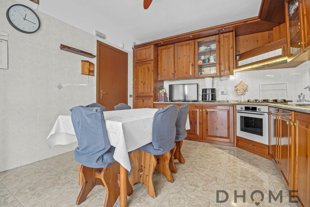 Angolo cucina in stile classico con mobili in legno e elettrodomestici moderni, ideale per case accoglienti e funzionali.