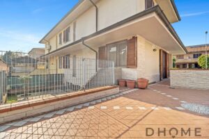 Balcone spazioso di casa con terrazzino in cotto e fioriere in terracotta.