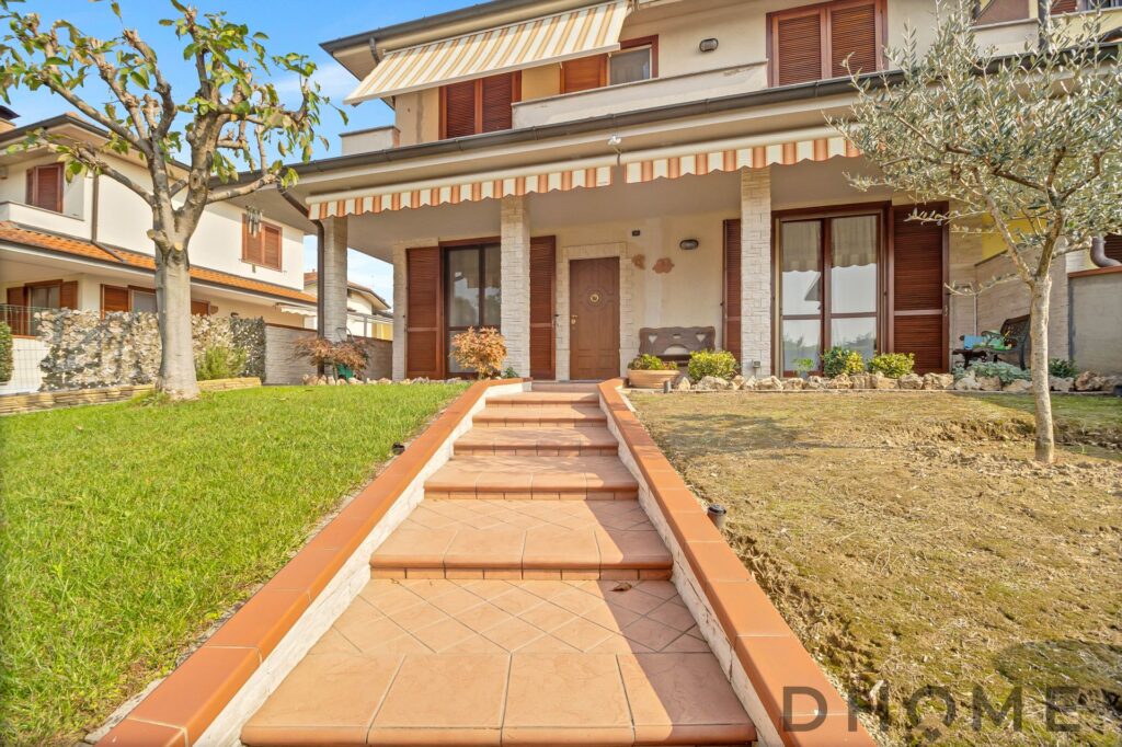 Entrata elegante di una casa con giardino ben curato, prossima a diventare la tua nuova casa dei sogni.