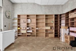 Mensole in legno non ancora installate in un ambiente di lavoro o negozio, con scatole e materiali di imballaggio.