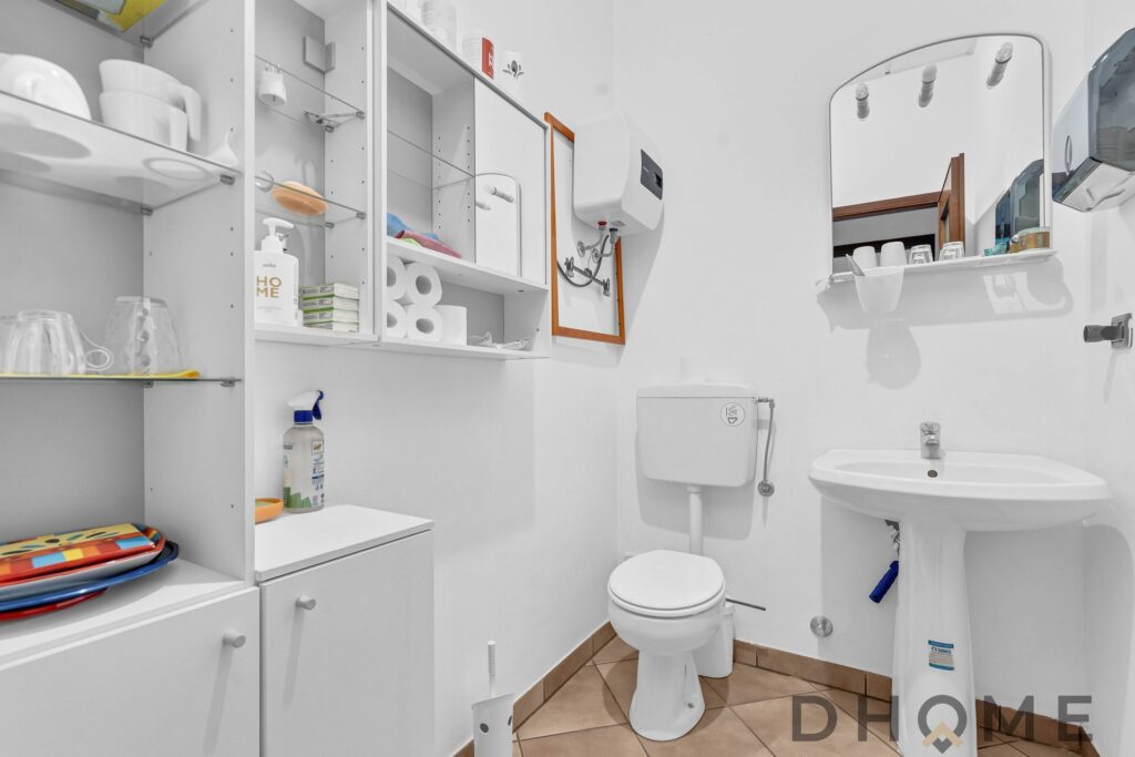 Lavabo e sanitari in bagno con mobili e accessori per l'igiene, ambiente pulito e funzionale.