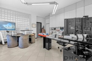 Sala riunioni con scrivania e monitor grande, arredi moderni e ambiente luminoso.