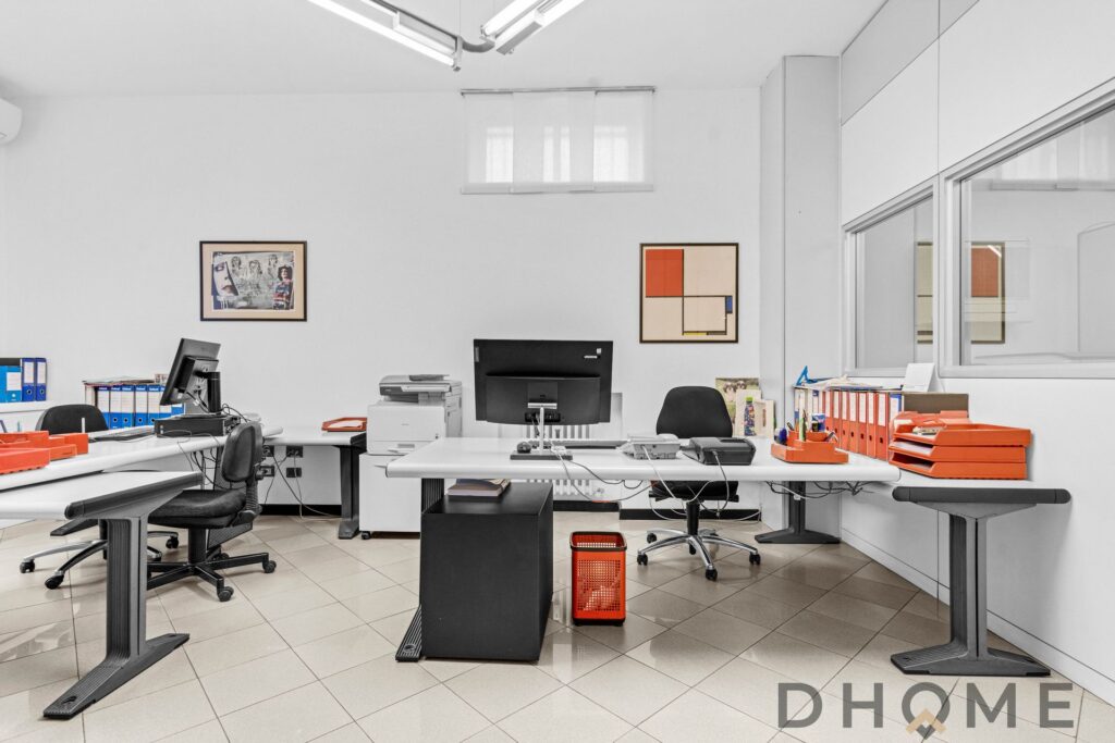 Ufficio moderno con scrivanie e apparecchiature di lavoro, ambiente professionale e funzionale.