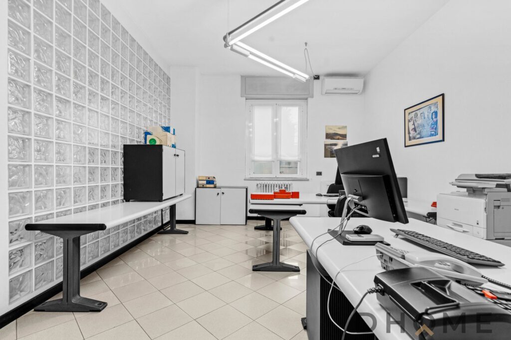 Finestra luminosa in ufficio con scrivanie moderne e arredamento minimalista.