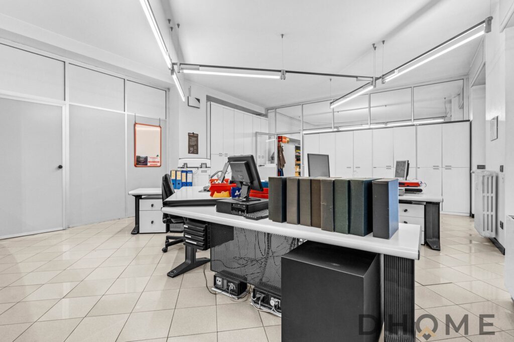 Scrivania ufficio moderna con computer e organizzatori, spazio di lavoro professionale in ambiente luminoso.