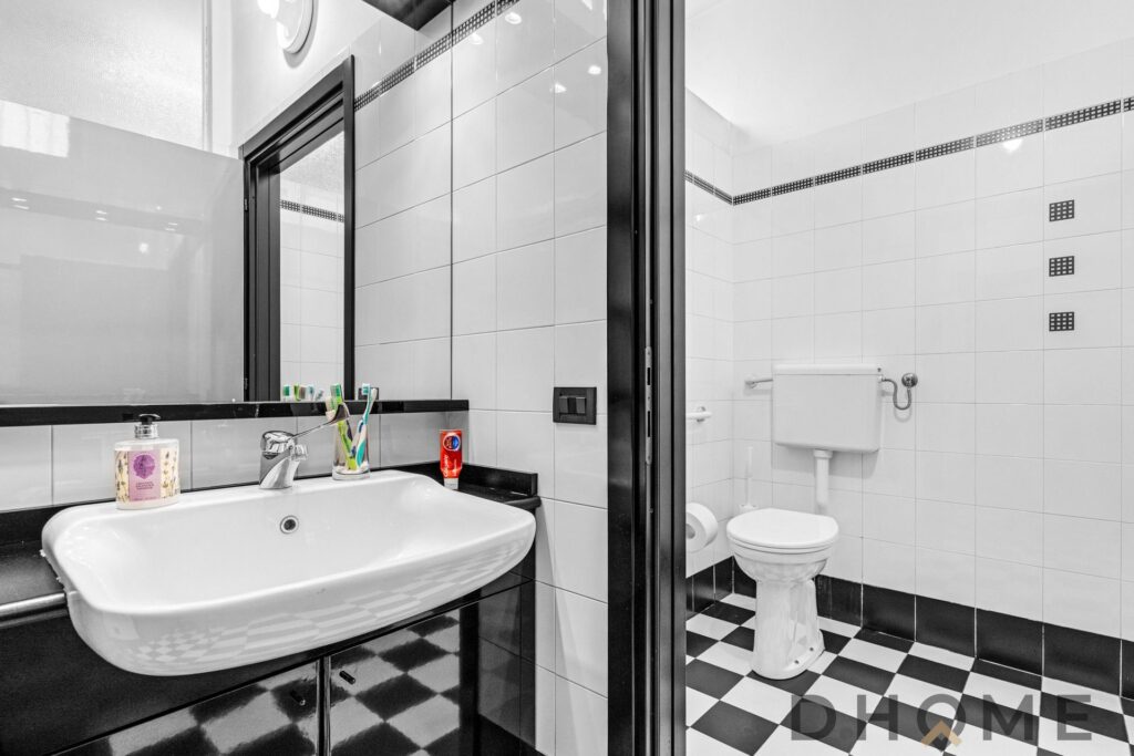 Lavabo e bagno in bianco e nero con piastrelle moderne, ideale per arredamento di bagno elegante e funzionale.
