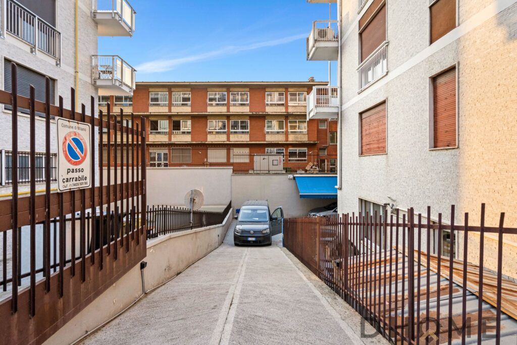 Auto in sosta nel cortile condominiale a Milano, spazio di parcheggio privato e ambiente residenziale.