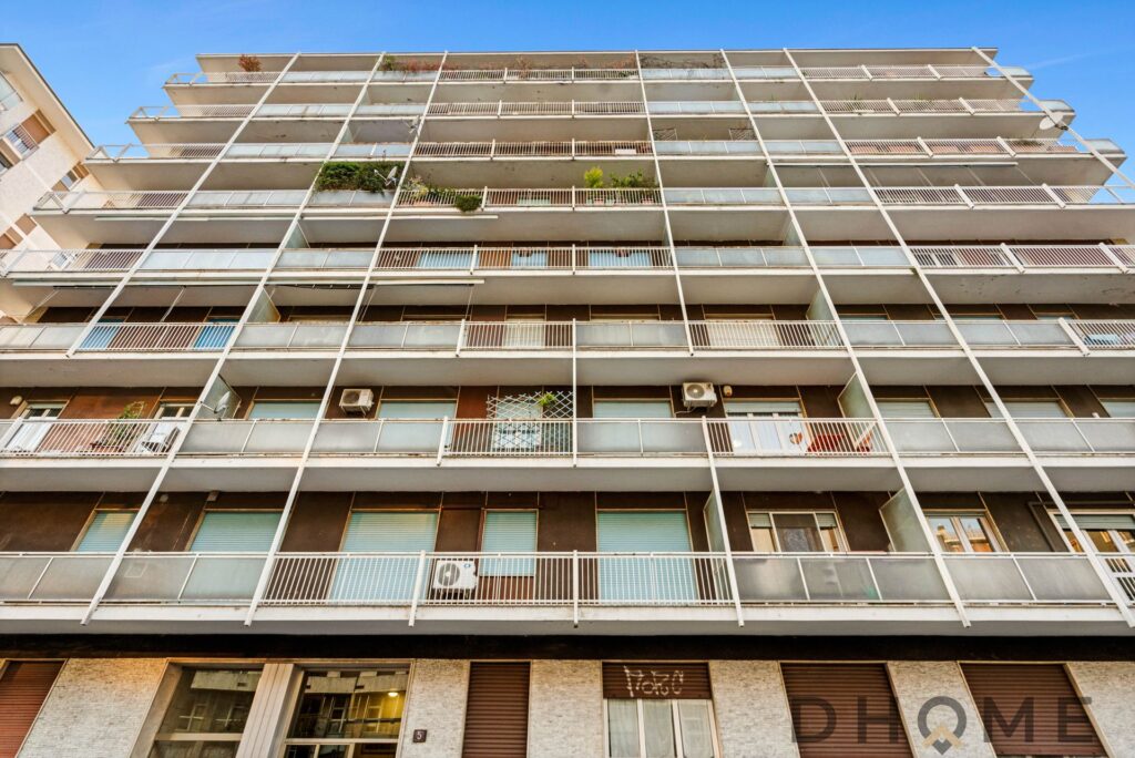Balcone di un edificio residenziale moderno con vasi di piante e aria condizionata.