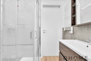 Specchio bagno moderno con lavabo in legno e radiatore scaldasalviette bianco.
