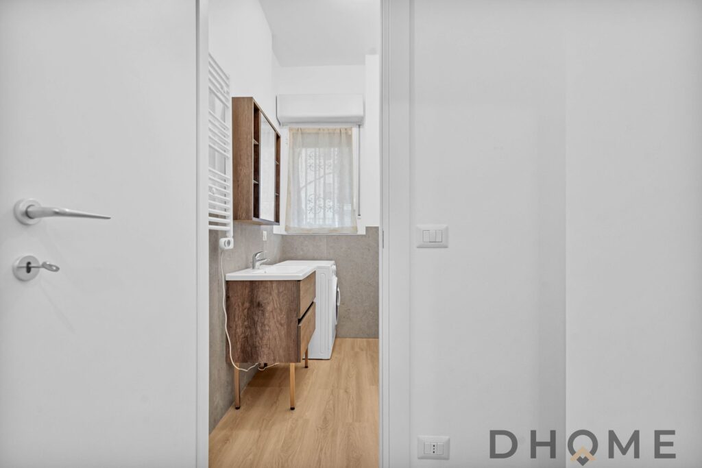 Lavanderia moderna con elementi in legno, spazio efficiente e luminoso, ideale per soluzioni abitative di qualità.