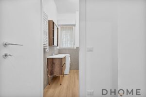 Lavanderia moderna con elementi in legno, spazio efficiente e luminoso, ideale per soluzioni abitative di qualità.