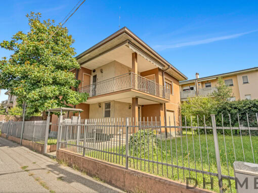 Casa bifamiliare con giardino e balconi, stile moderno e serramenti efficienti.