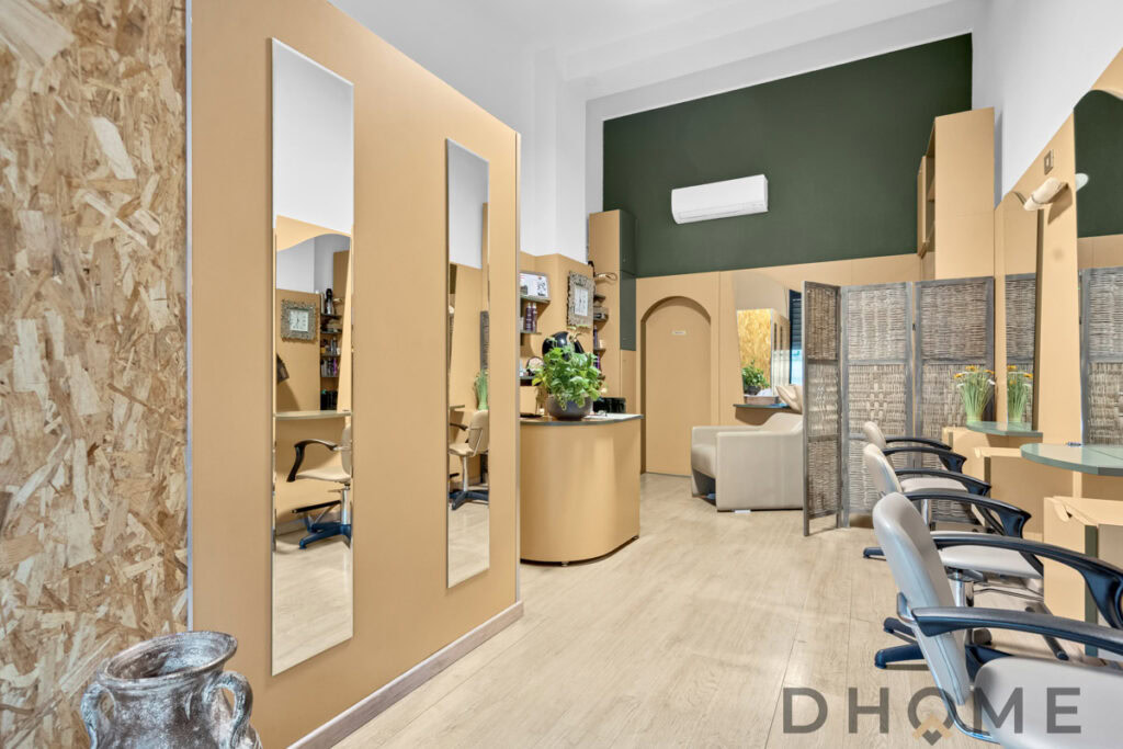 Interni moderni studio di bellezza con sedie e specchi, ambiente accogliente e luminoso.